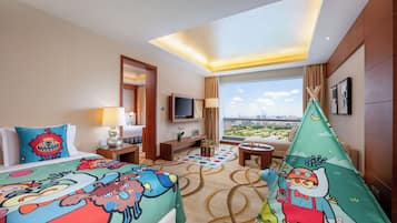 A hotel room with two beds, a TV, a window with a city view, and a green tent-like decoration.