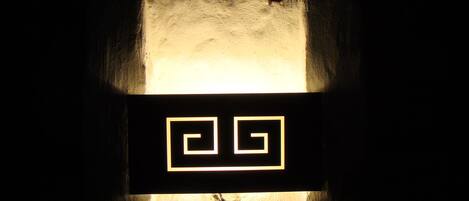 Una habitación oscura con un diseño geométrico iluminado en la pared.