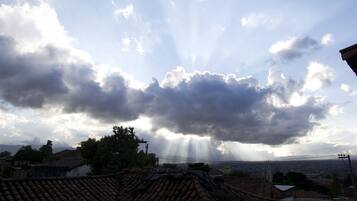 Paesaggio urbano con cielo nuvoloso e raggi di sole.