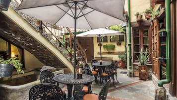 A courtyard with outdoor seating, a staircase, and potted plants.
