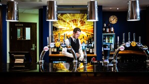 A bar area with multiple taps, including Guinness, and a clock on the wall. - Drayton Manor Hotel (Tamworth)