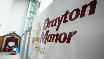 A sign for Drayton Manor Hotel with a logo and the name.