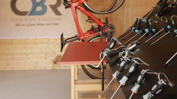 Una habitación con techo de madera, una bicicleta roja y un soporte mural con herramientas.