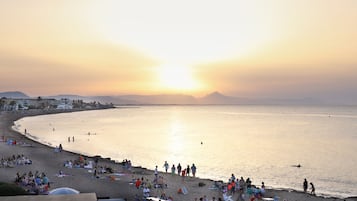 Une plage où des gens se détendent et se promènent le long du rivage.