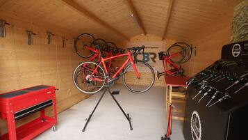 A wooden ceiling, a red bicycle on a stand, a red tool chest, and a wall-mounted sign.