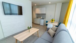 A modern living room with a sofa, a wooden coffee table, and a TV mounted on the wall. - Lemon & Soul Las Palmas (Las Palmas de Gran Canaria)