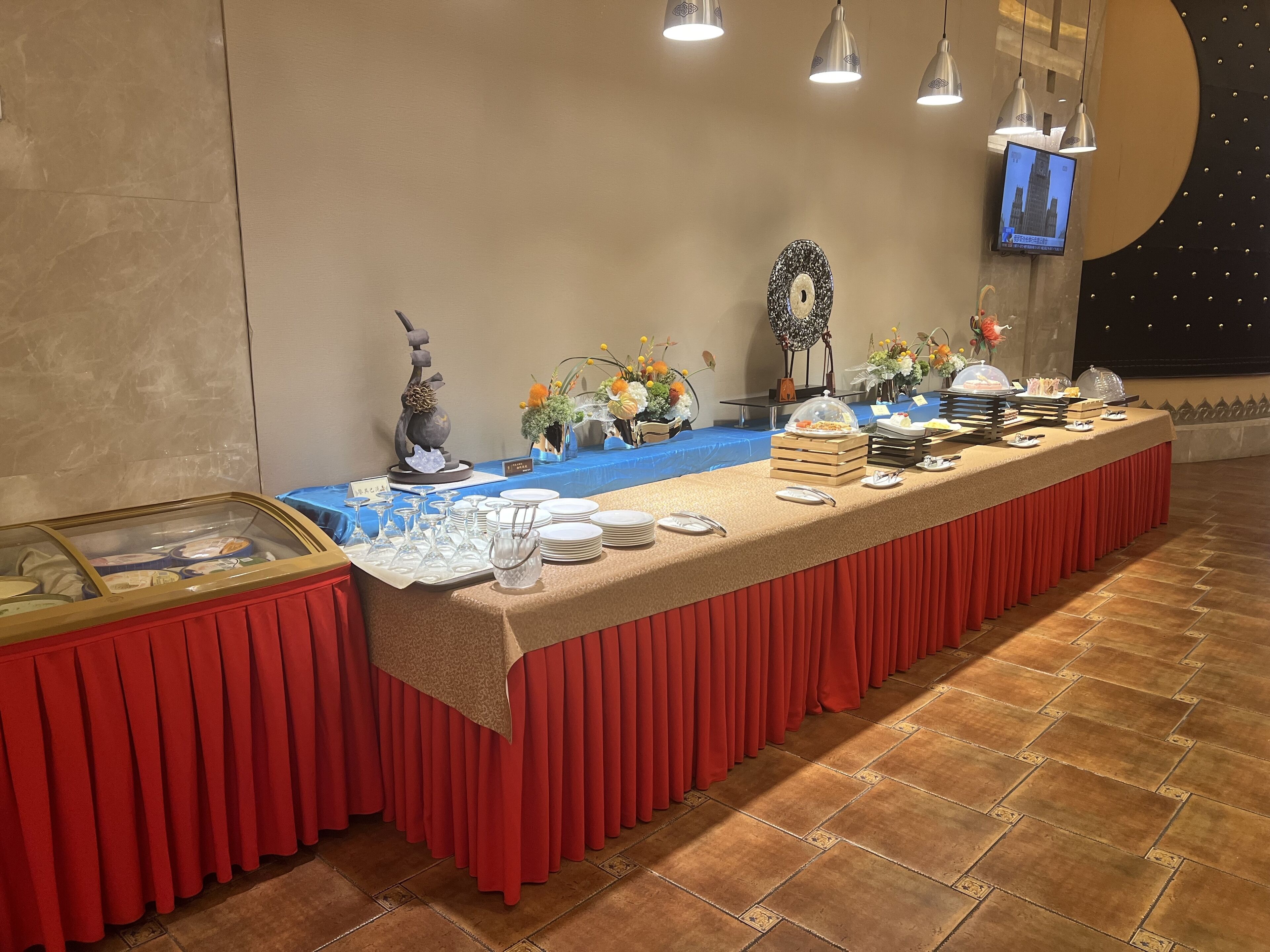 Ein reichhaltiges Buffet mit einer langen Tafel, Gläsern und Blumenarrangements.