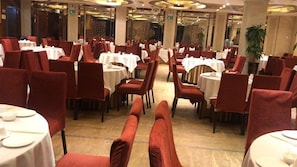 A restaurant with round tables and red chairs, arranged in a spacious layout. - Jiangyue Hotel - Guangzhou (Guangzhou)