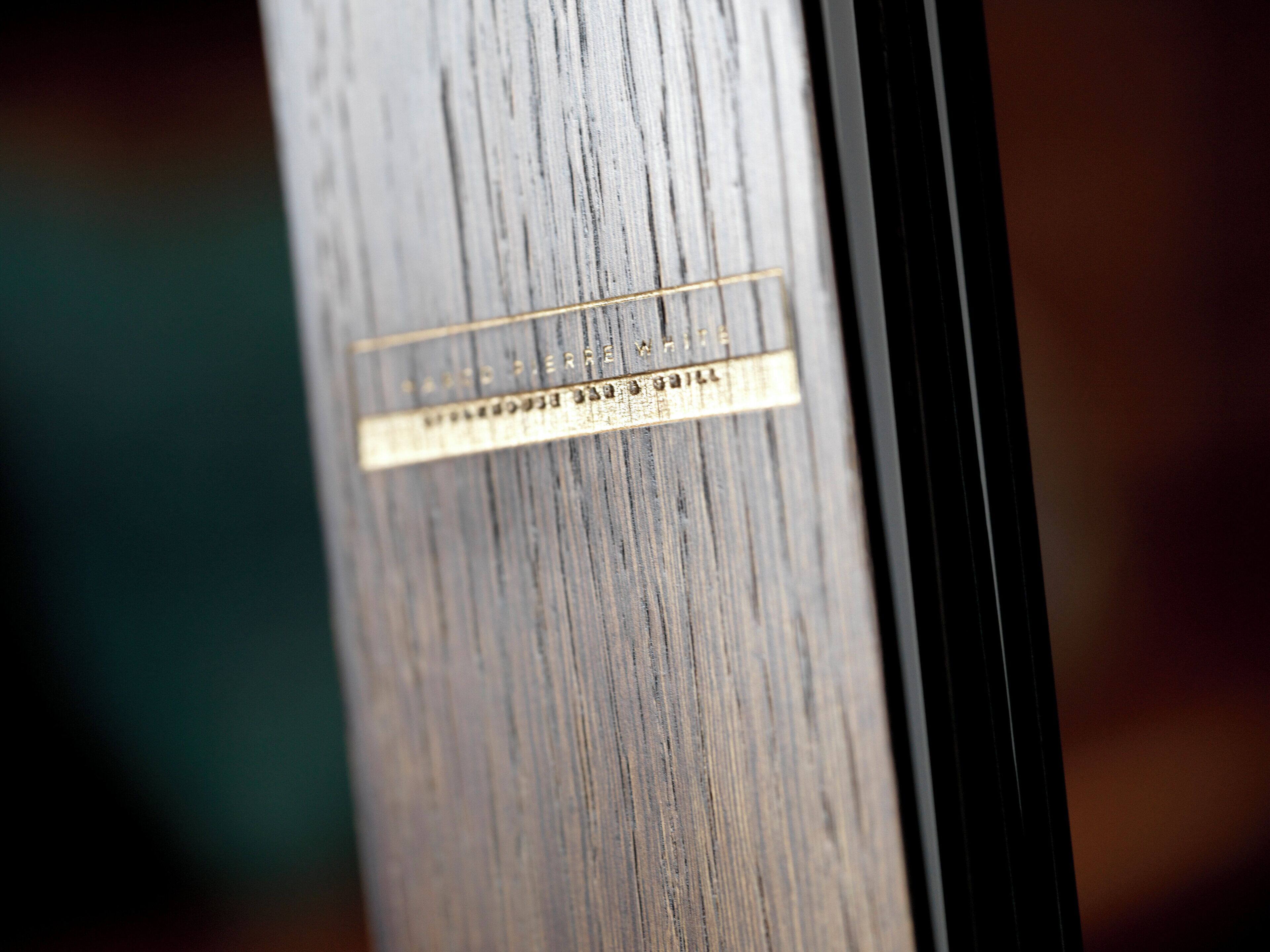 A close-up of a wooden surface with a metal plaque.