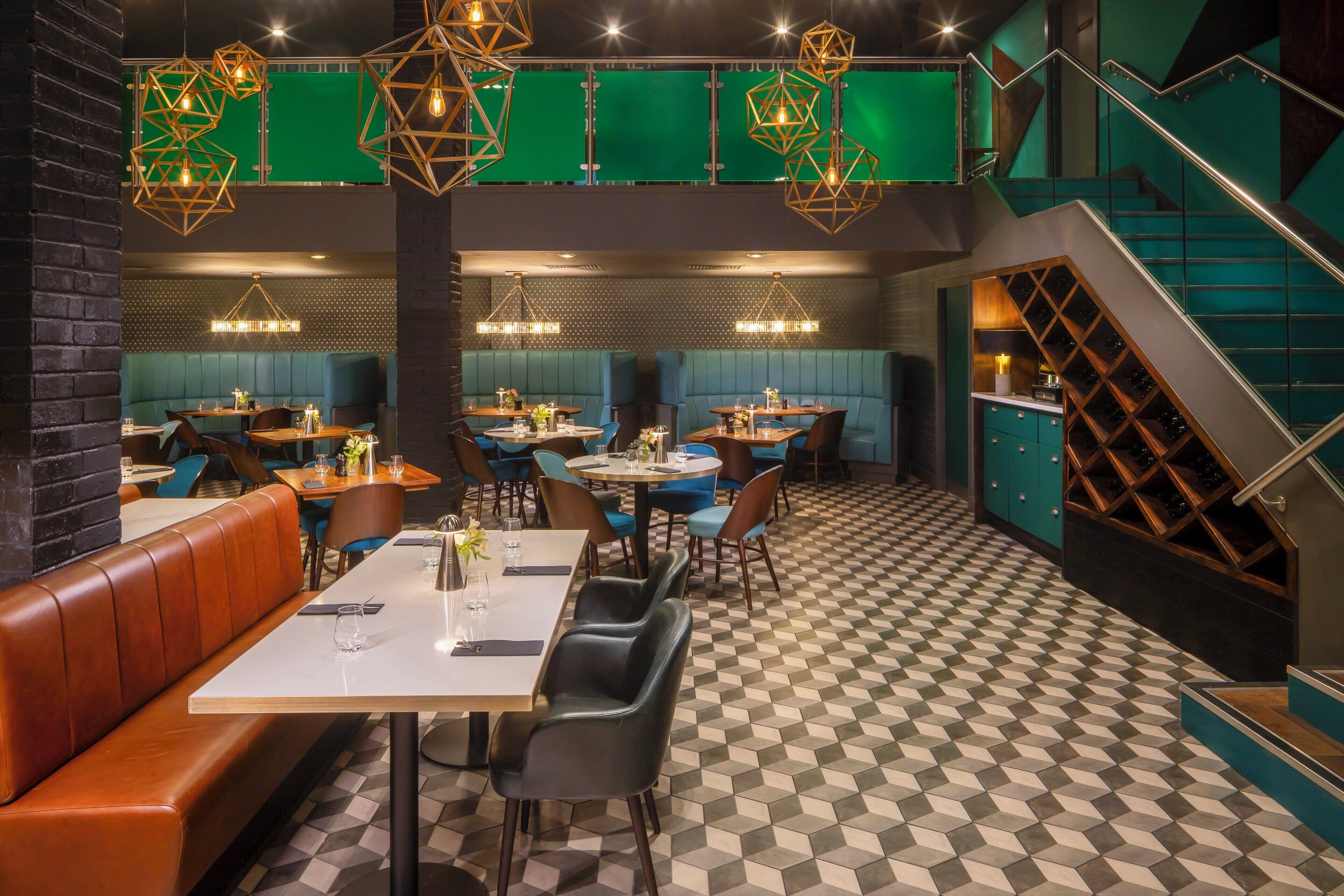 A restaurant with booths, tables, and a checkered floor.