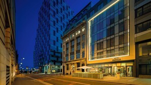 A hotel with a classic facade, modern glass windows, and a well-lit entrance.