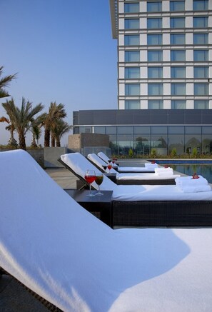 Piscine extérieure, parasols de plage, chaises longues