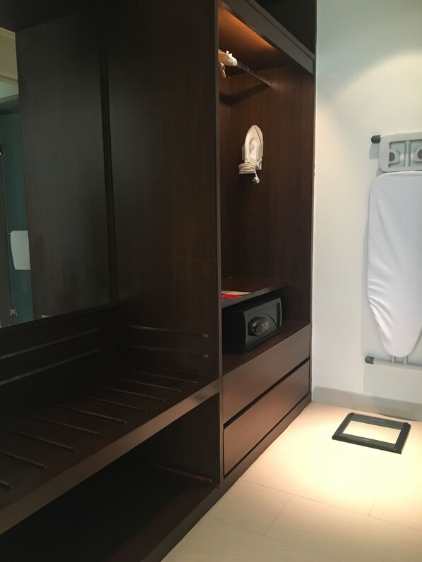 A walk-in closet with dark wood shelving, a microwave, and a small appliance on the countertop.