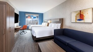 Une chambre d’hôtel avec un grand lit, un canapé, un bureau avec une chaise et une télévision.