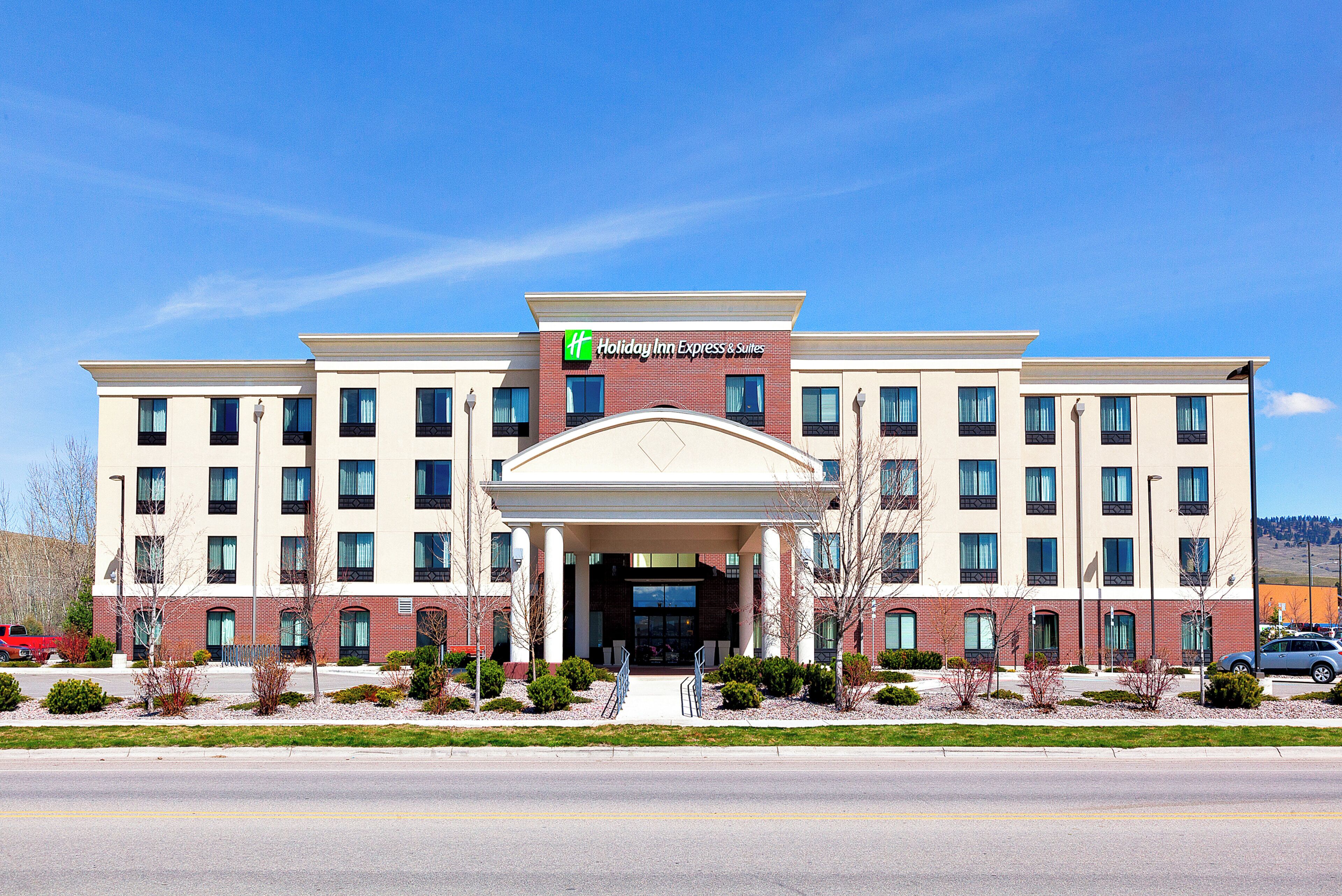 A Holiday Inn Express & Suites hotel with a central entrance, multiple floors, and a flat roof.