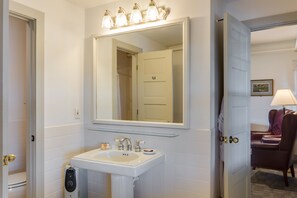 A bathroom with a white sink, a mirror, and a shower door.