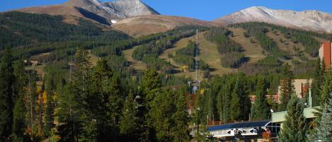 A mountain landscape with a lake, a bridge, and buildings with a view of the mountains.