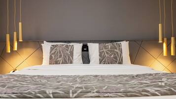 A modern bedroom with a large bed, a headboard with a geometric pattern, and pendant lights.