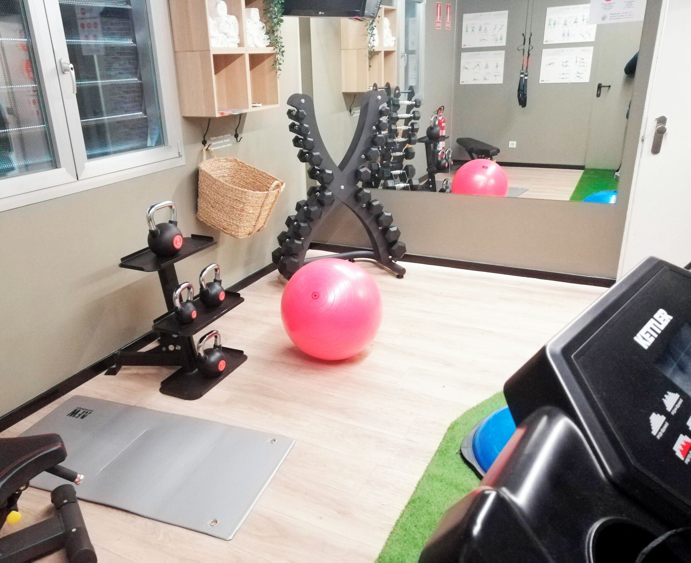 A gym with exercise equipment, a mirror, and a mat.