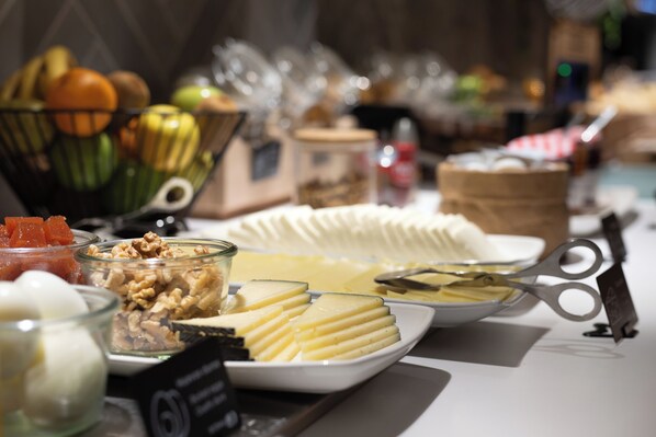 A buffet table with various food items including fruits, nuts, and cheese. - Hotel Bed4u Pamplona (Galar)
