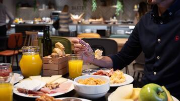 A breakfast setting with various food items and drinks on a table.