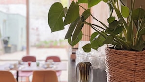 A dining area with a table, chairs, and a potted plant. - Botaniek (Bruges)