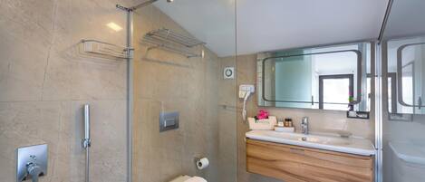 A modern bathroom with a glass shower enclosure, a built-in sink with a wooden vanity, and a large mirror above the sink.