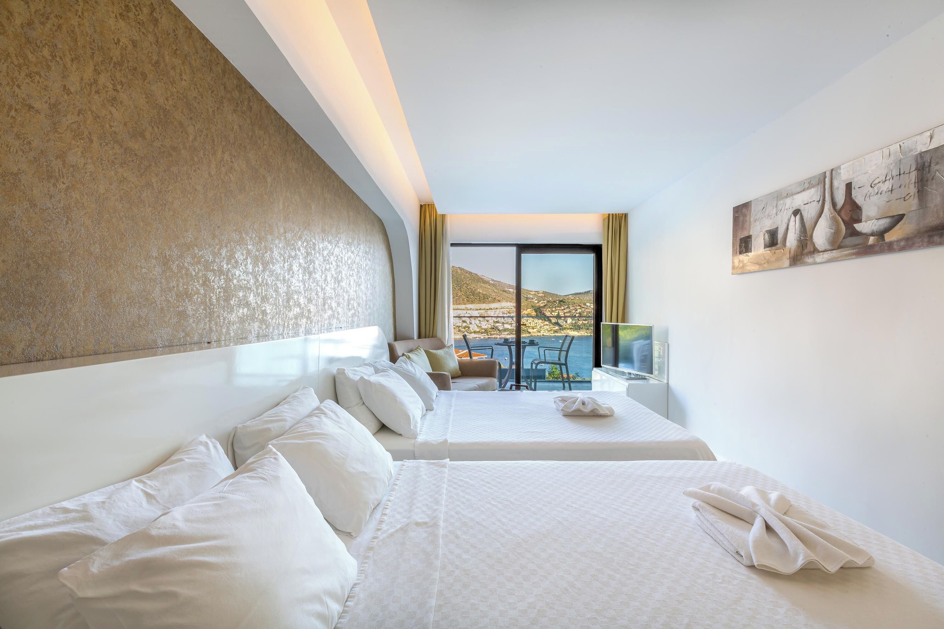 Habitación de hotel con dos camas, un sofá, una mesa y vista al paisaje.