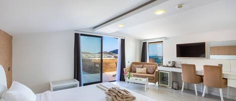Una habitación de hotel moderna con una cama grande, un escritorio y un sofá.