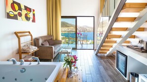 A modern living room with a large window, a sofa, a coffee table, and a view of the sea.