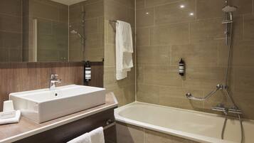 Un baño moderno con un lavamanos grande, una bañera y una ducha.