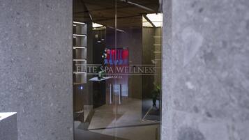 Un interior de spa moderno con una recepción, techo de madera y pared de vidrio.