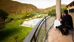 Un balcón con vista a una piscina y un paisaje montañoso.
