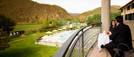 A balcony with a view of a swimming pool and a mountainous landscape.