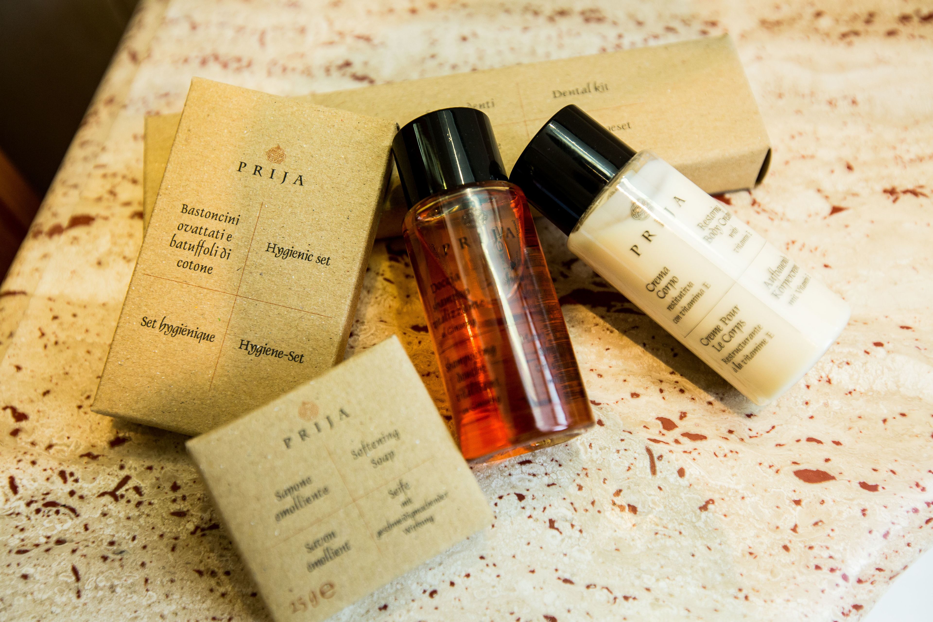 A set of hygiene products including a box labeled "PRIJA" and two bottles, one with a black cap and the other with a white cap.