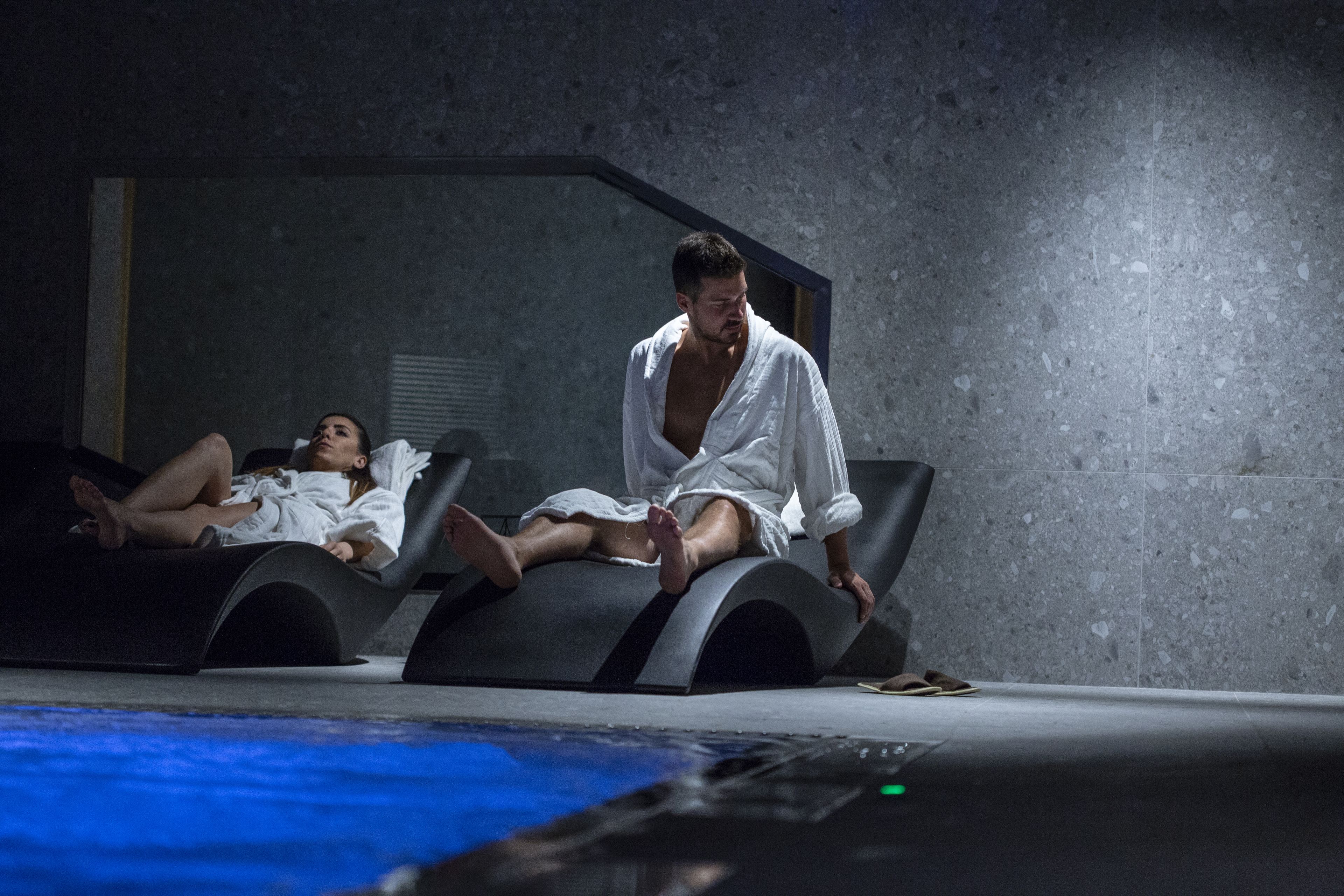 Un spa moderno con dos sillones reclinables y una piscina.