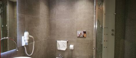 Un bagno moderno con un lavandino bianco ampio, un mobile bagno rosso, un bidet e un box doccia.