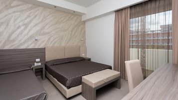 Une chambre d’hôtel moderne équipée d’un grand lit, d’un lit plus petit, d’un bureau et d’une chaise.