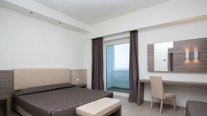 A modern hotel room with a large bed, a desk, a chair, and a window with curtains. - Hotel Village Club Santa Caterina (Scalea)