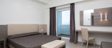 Une chambre d’hôtel moderne, dotée d’un grand lit, d’un bureau, d’une chaise et d’une fenêtre avec des rideaux.