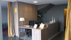 A hotel reception desk with a computer, a chair, and a desk lamp. - Hotel Vila de Premià (Premia de Mar)