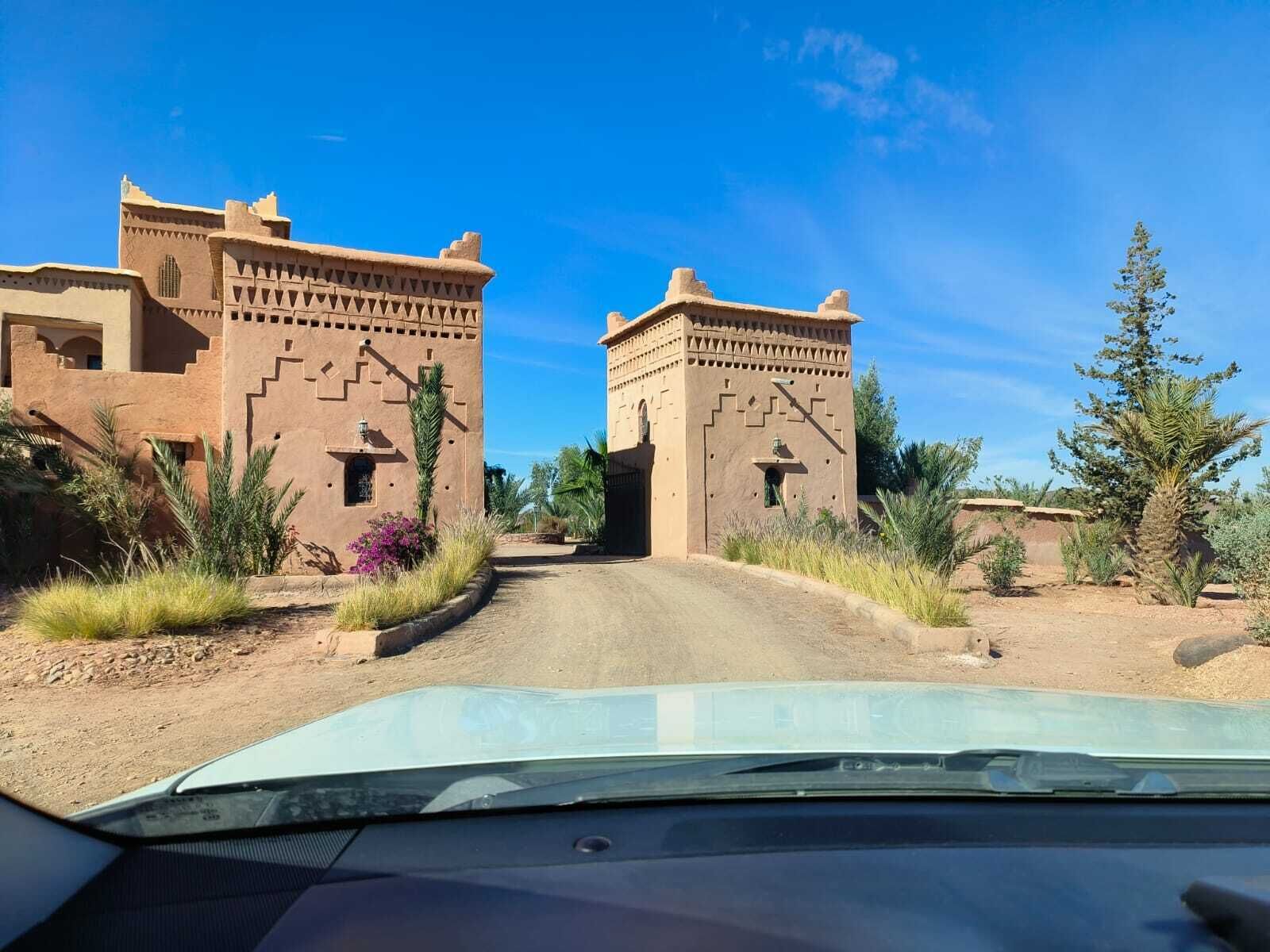 Woestijnlandschap met traditionele adobe gebouwen en een zandweg die erdoorheen leidt.