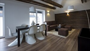 Un salon moderne avec un coin repas, un plancher en bois et des poutres apparentes.