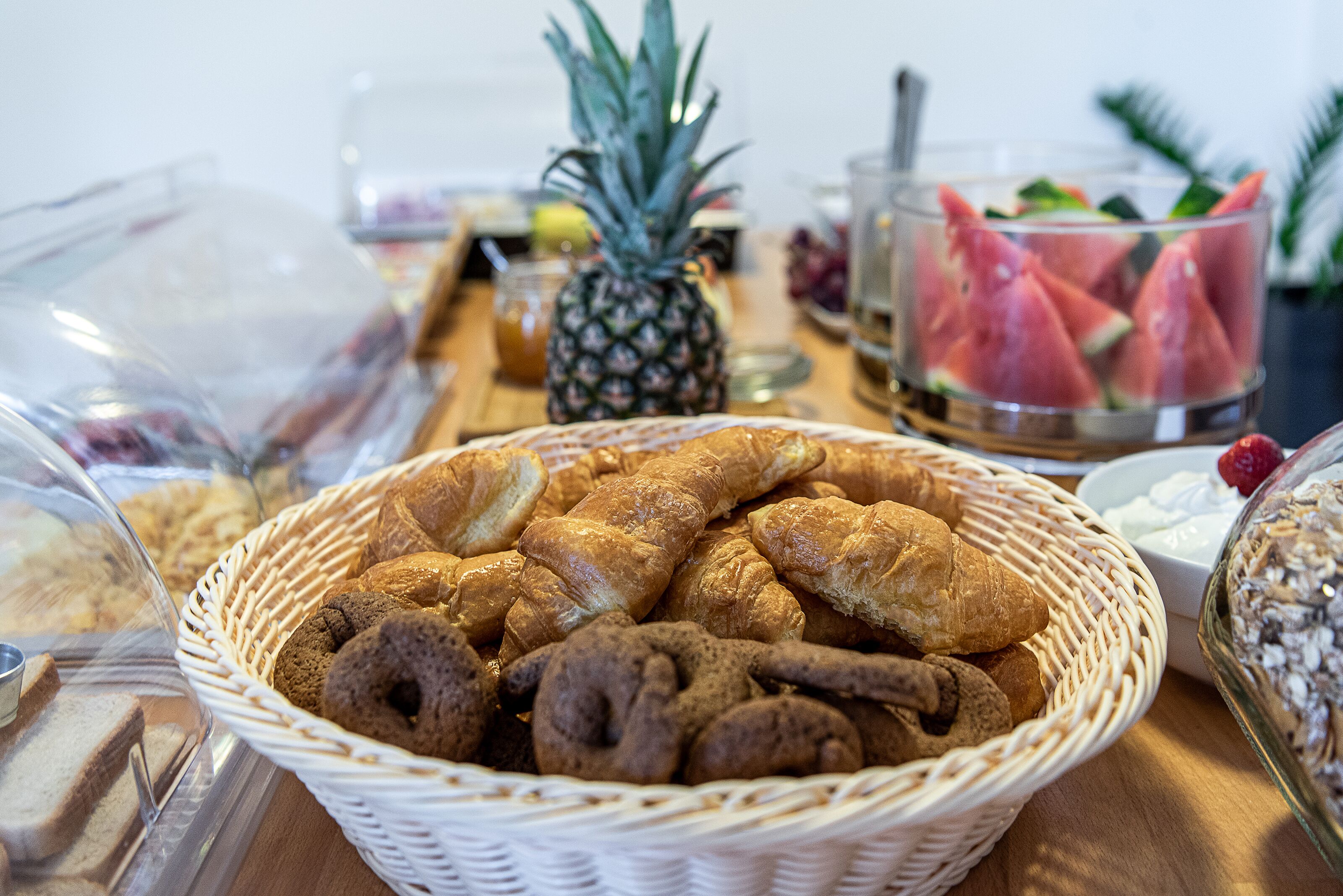 Ein Frühstücksbuffet mit verschiedenen Backwaren, Brot und Früchten.