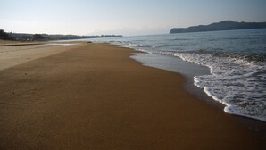 A beach with a wide sandy shore and gentle waves. - Artemis Apartments (Chania)