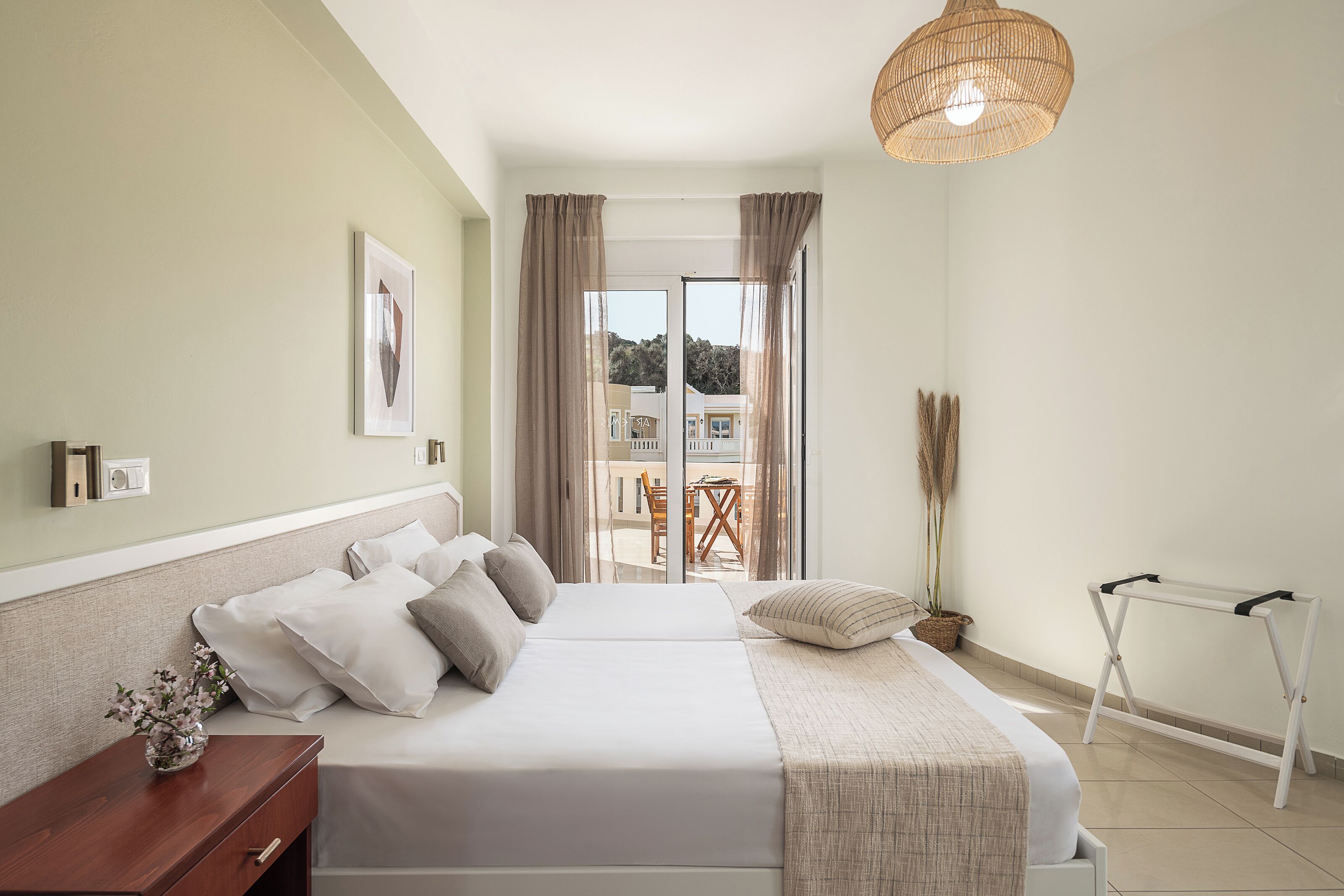Un dormitorio con cama, mesita de noche y vistas al exterior.