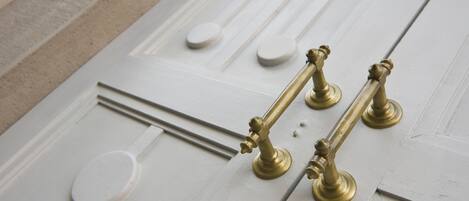 A white door with brass handles and a round doorknob.