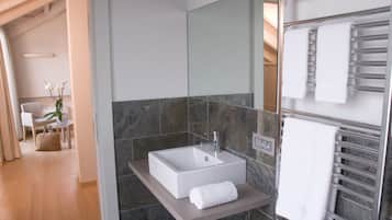 Un baño moderno con un lavamanos grande rectangular, un espejo y un perchero para toallas.