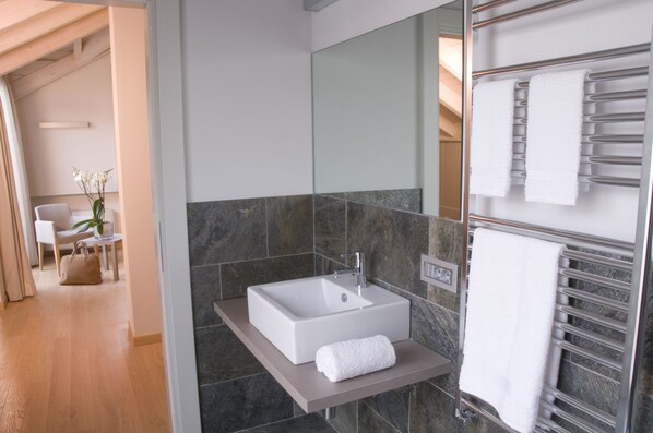 Un baño moderno con un lavamanos grande rectangular, un espejo y un perchero para toallas.
