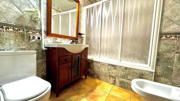 Een badkamer met toilet, wastafel en bad.